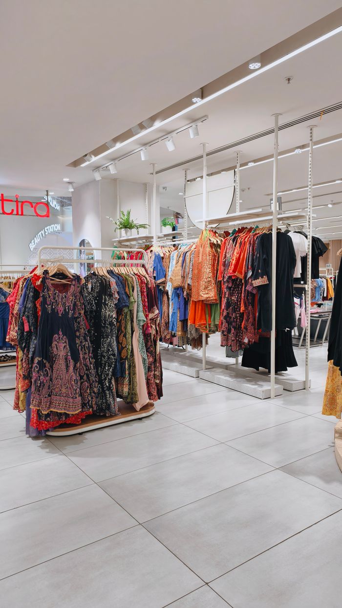 Rows of colorful clothing on racks in a stylish fashion boutique interior.