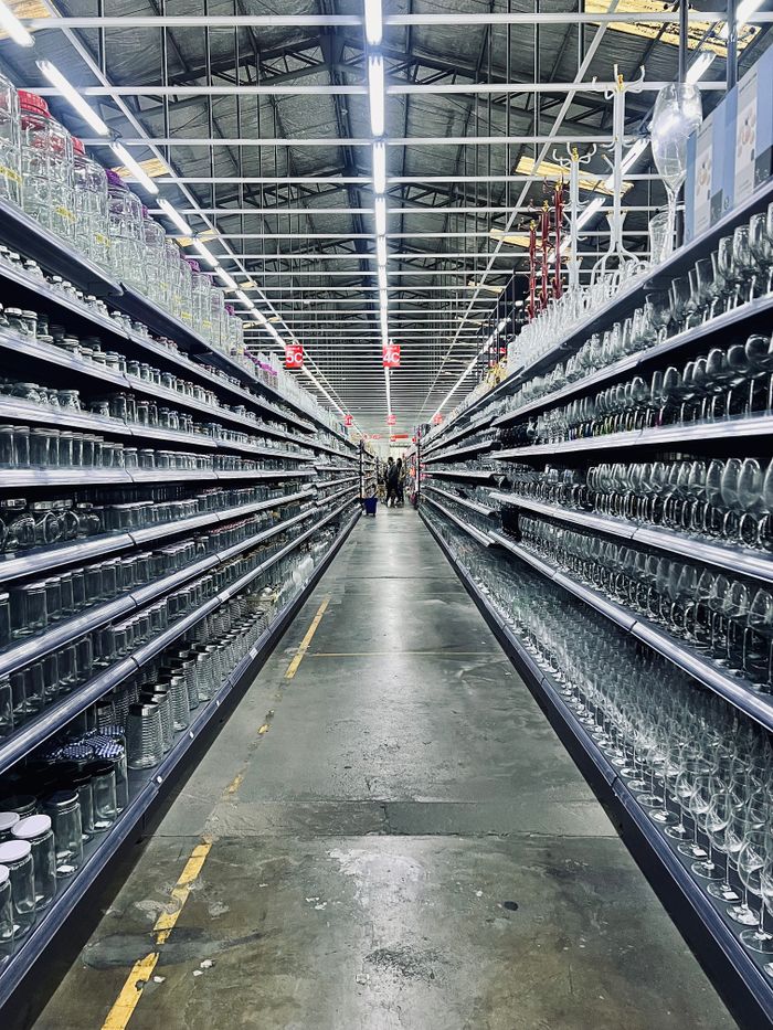 Long aisle with glassware in a modern store setting.